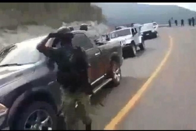 En el video se aprecia que cerca de 15 vehículos están parados en fila en un tramo carretero, y en él hay varios hombres armados
