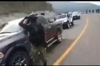 En el video se aprecia que cerca de 15 vehículos están parados en fila en un tramo carretero, y en él hay varios hombres armados