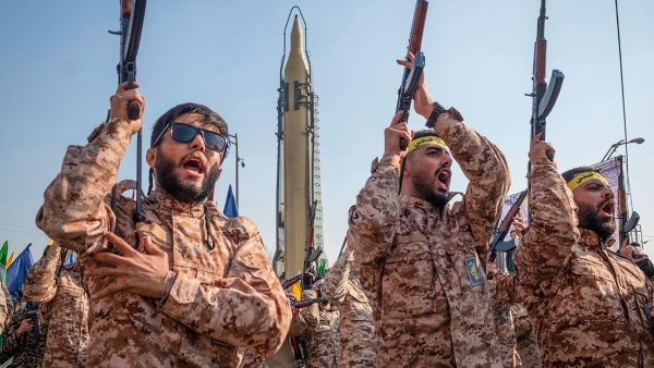 Militares del CGRI portan fusiles AK-47 y marchan junto a un misil iraní de largo alcance superficie-superficie durante un desfile militar en el centro de Teherán, Irán, el 10 de enero de 2025