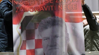 Bosniocroatas sujetan una bandera que muestra a Slobodan Praljak, en Mostar (Bosnia) este miércoles, tras el suicidio del exgeneral.